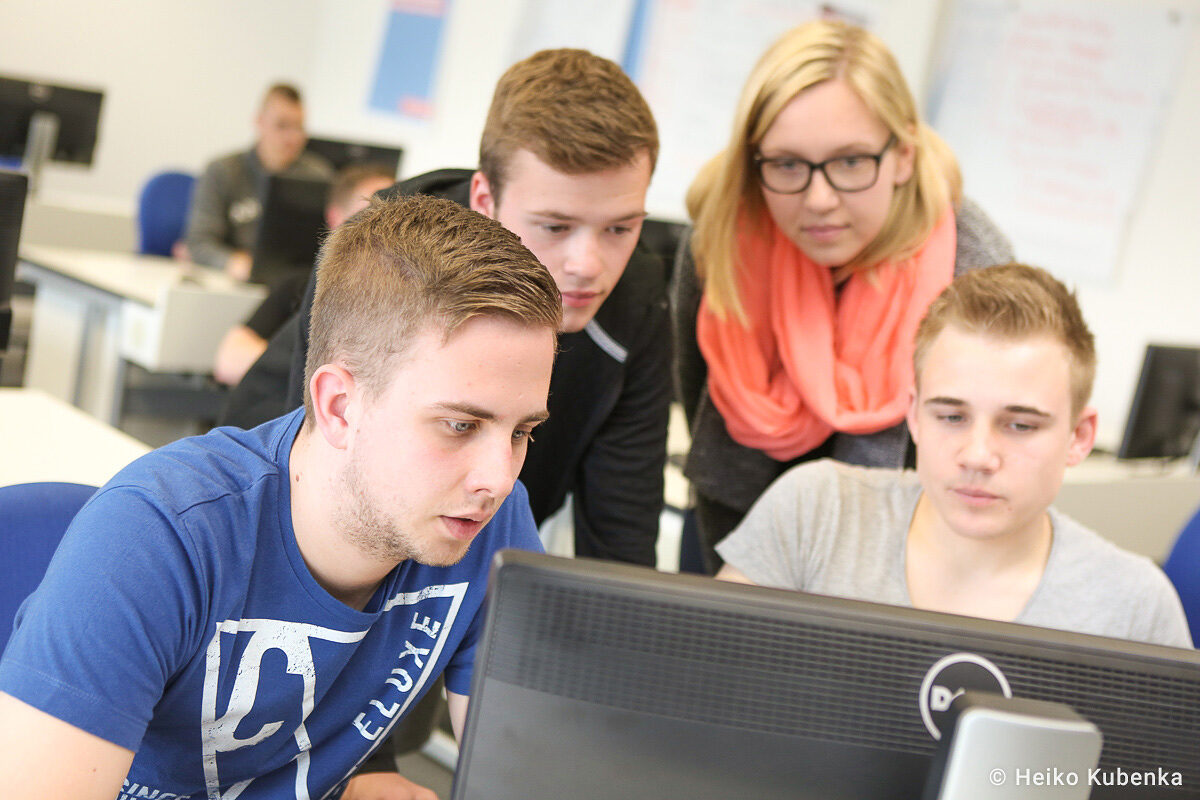 Seminarteilnehmer am PC. Seminarteilnehmer schauen zusammen in einen PC-Bildschirm.