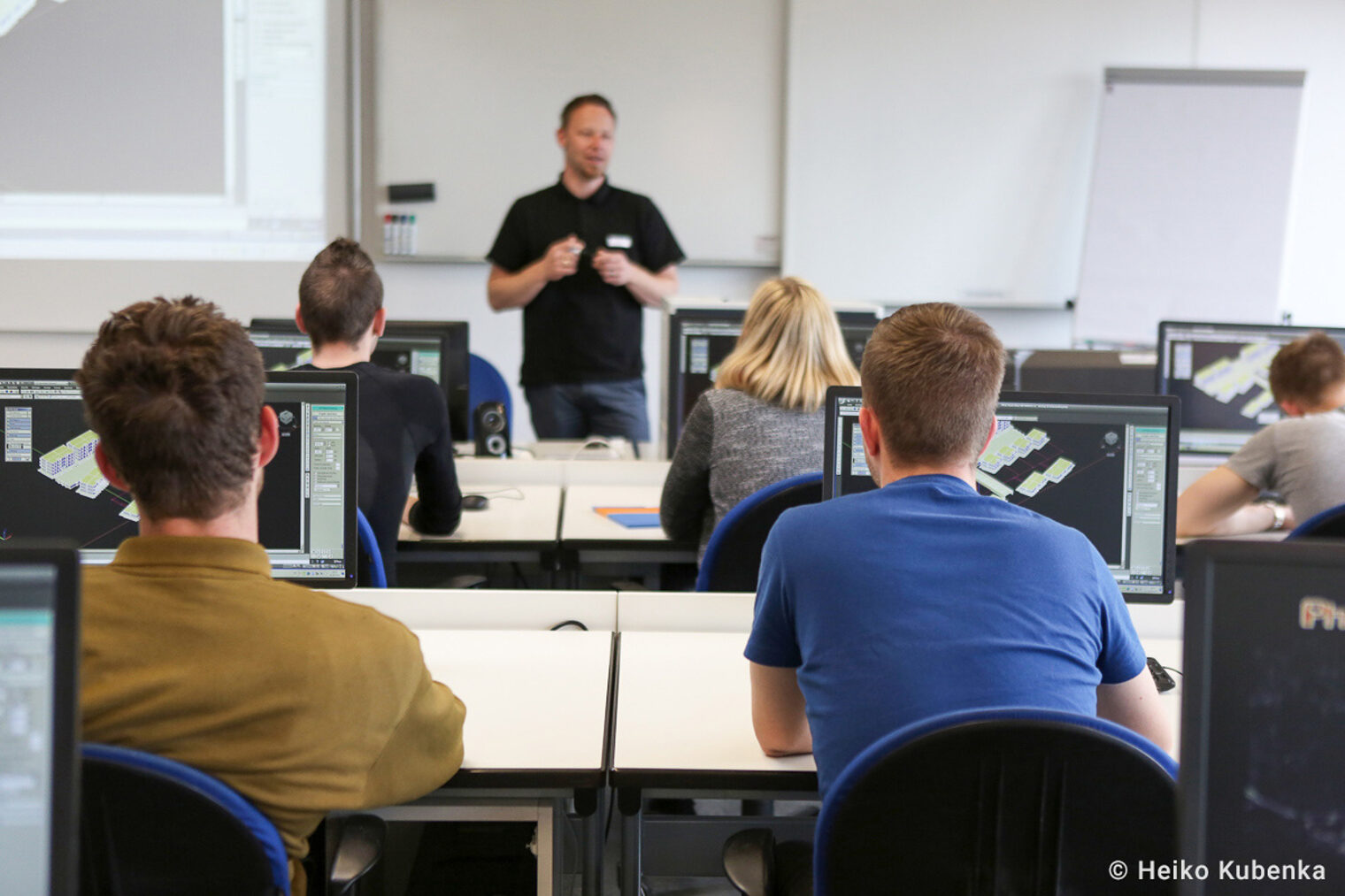 Dozent unterrichtet in Klasse. Dozent unterrichtet Azubis. Azubis hören zu.